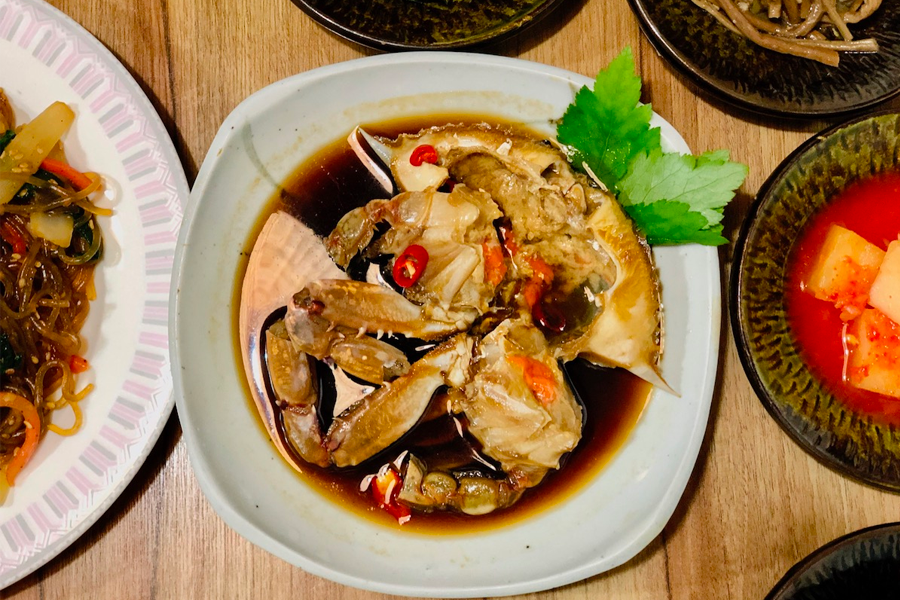 傳統韓國料理，以醬蟹為正中央展示，兩旁圍繞著各種小菜和韓國煎餅。