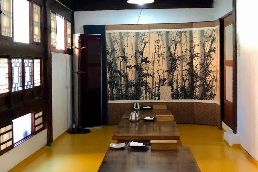 用餐室內部的長桌，牆上裝飾漆畫，營造出韓屋的氛圍。