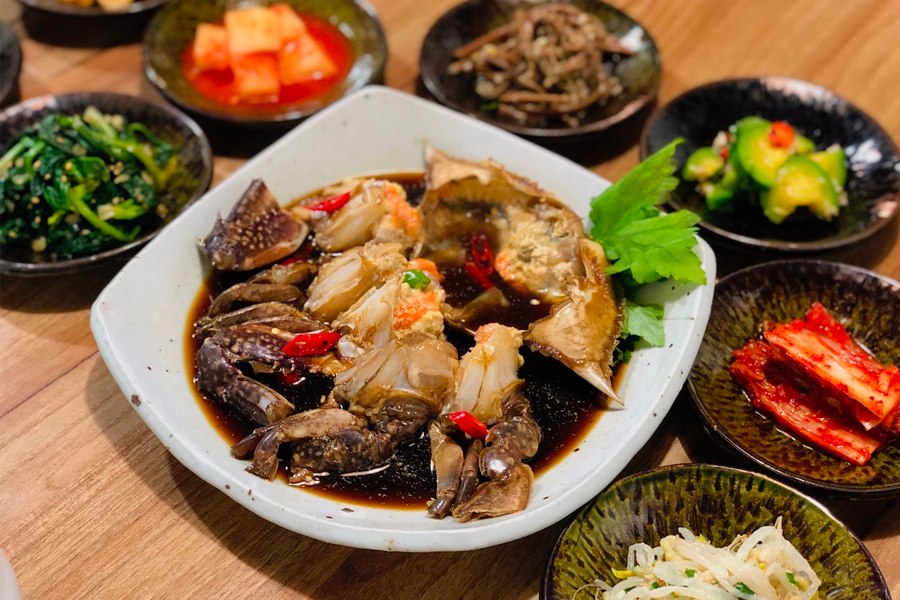 特寫的醬蟹盤，周圍配有多樣的韓式小菜，增添了視覺的吸引力。