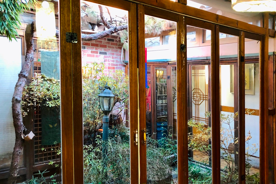 餐廳內部的庭院，可見落地窗和傳統裝飾的室內小花園。