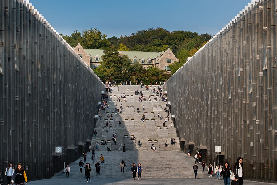 梨花女子大学的大峡谷，巨大的建筑夹道而立，学生们三三两两地穿过石阶。