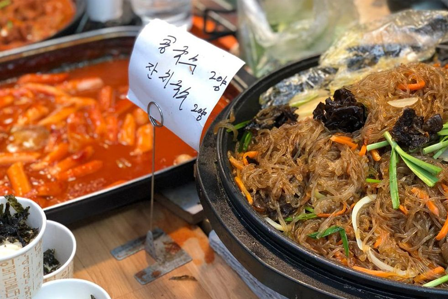 通仁市场内的摊贩，展售着色彩鲜艳的韩式料理和美味小吃。