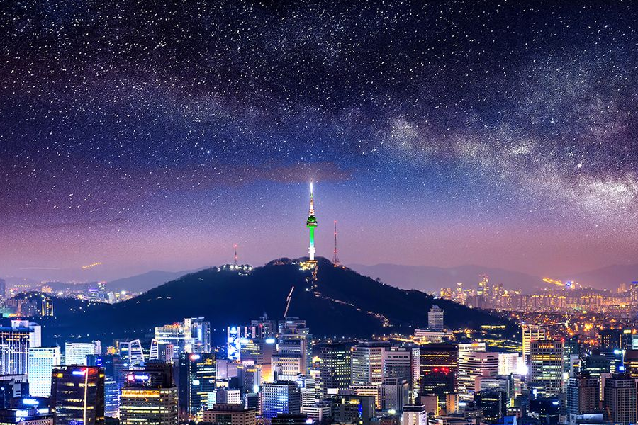 首尔南山俯视图，夜晚城市灯光闪耀，山顶的首尔塔笔直耸立。