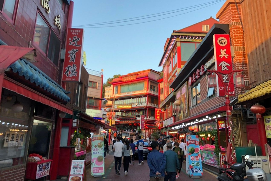 仁川中国城内的街景，传统中式建筑与现代商铺交错，而人群穿行其间。