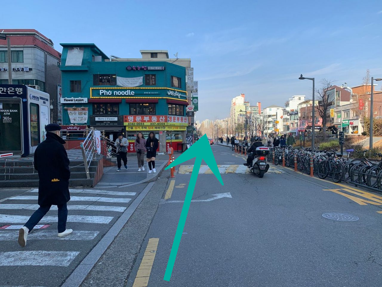 乘客從弘大地鐵站3號出口出來的街道景觀，鄰近有各種商店和行人。