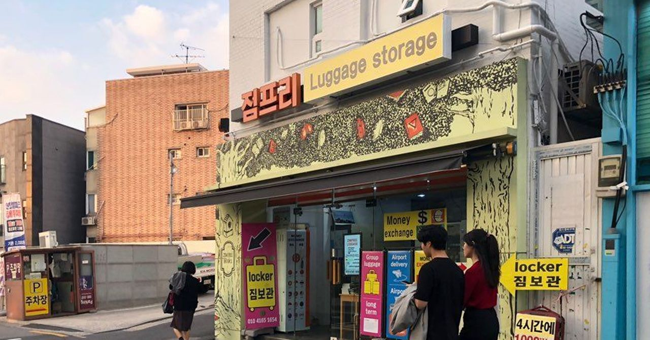 一間提供行李保管服務的店鋪外觀，宣傳標語顯示在牆上。