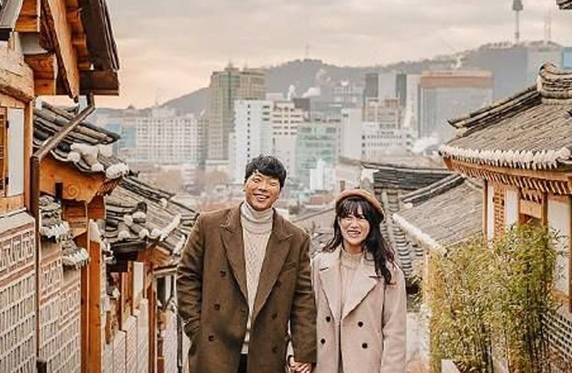 北村韓屋村的傳統韓屋景觀，背景是首爾的現代化城市天際線，融合了歷史與現代，是遊客喜愛的文化體驗區。