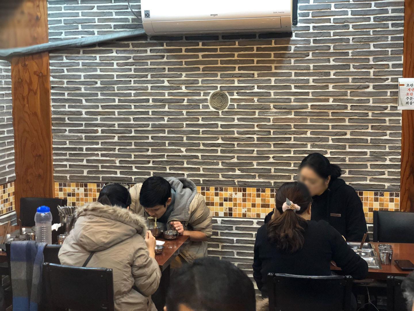 ソウルの武橋洞プゴグッチッで幹し鱈スープを楽しむ人々。暖かい雰囲気の店内で、韓国料理の美味しさを堪能しています。