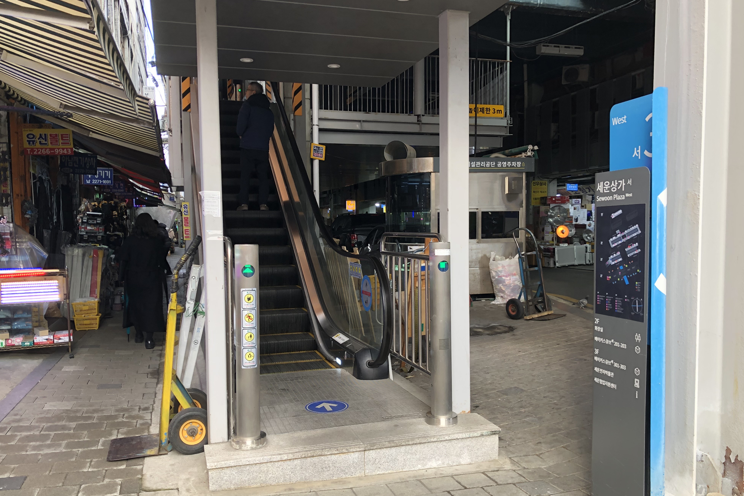 서울 세운상가의 에스컬레이터 입구. 활기찬 거리와 에스컬레이터가 어우러진 모습.