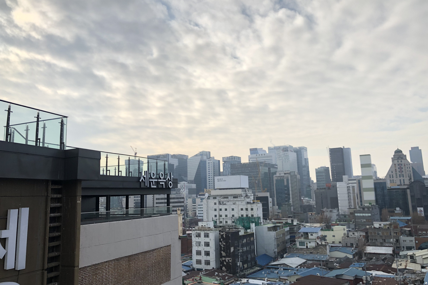 서울 세운상가 옥상에서 바라본 도심 경관. 높은 빌딩과 함께 평화로운 하늘이 펼쳐져 있다.