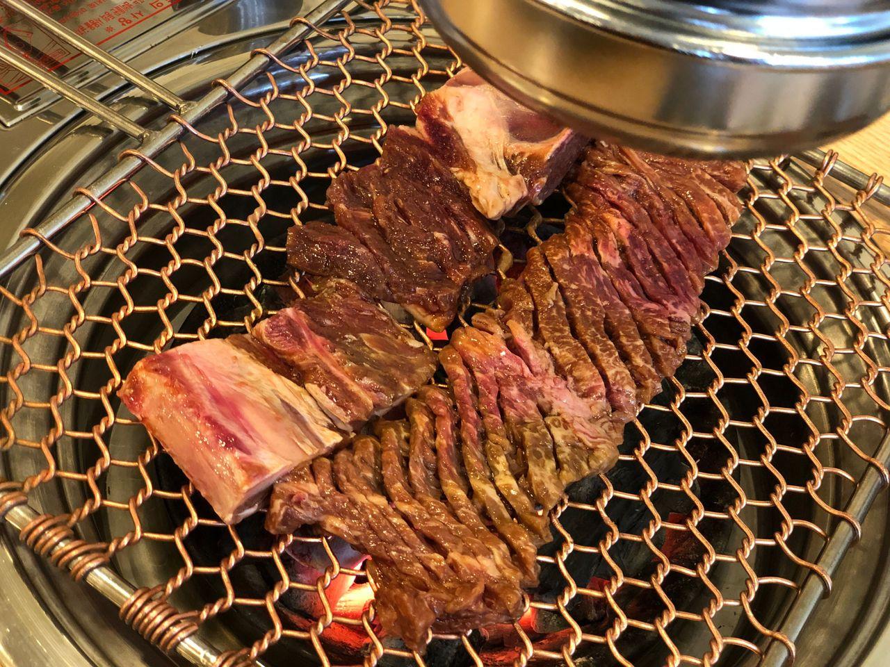 五道麵屋のグリルで焼かれているカルビ肉。美味しそうに焼け始めている。