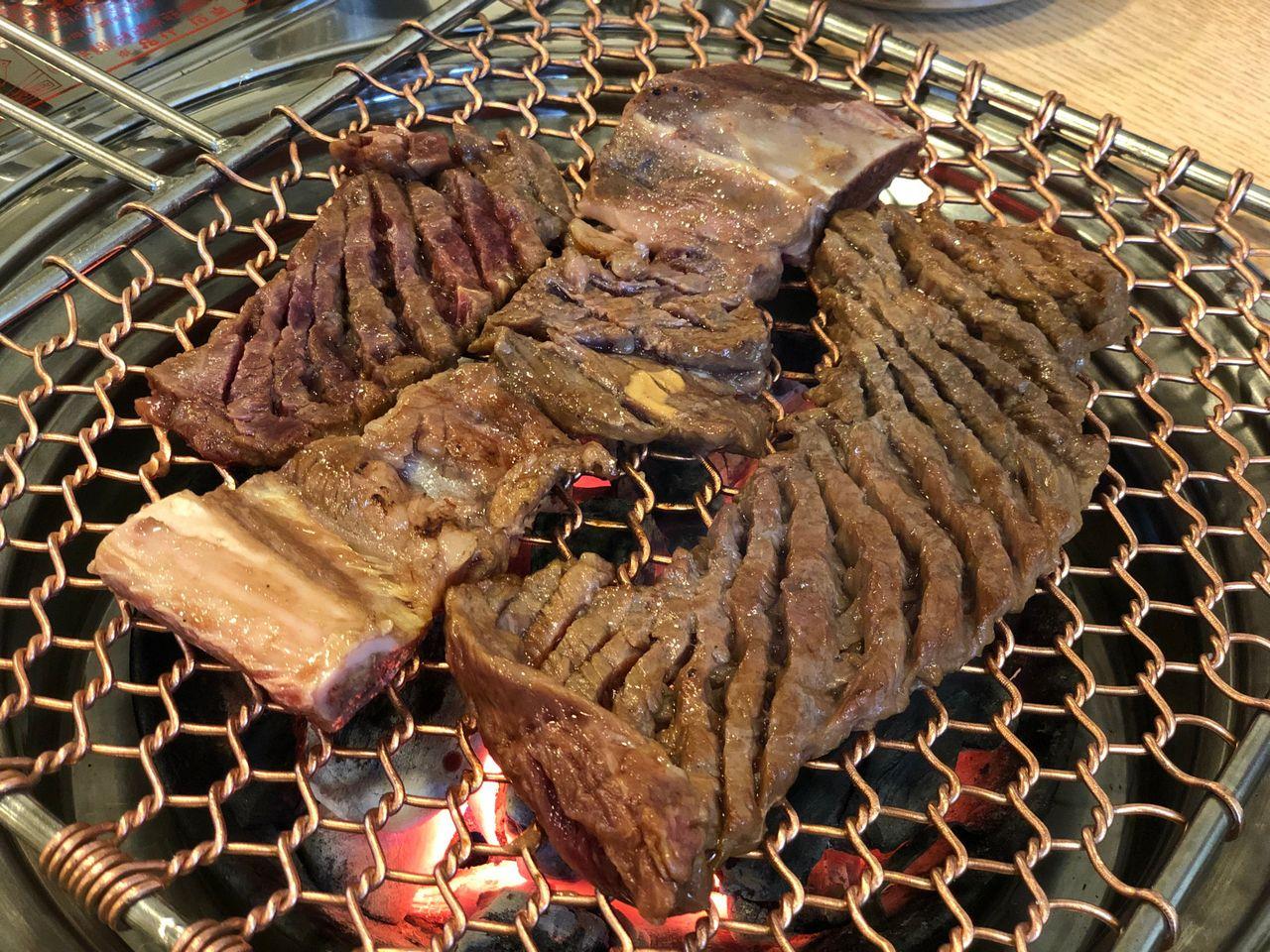 カリカリにグリルされたカルビ肉。香ばしい香りとともに美味しそうに焼かれている。