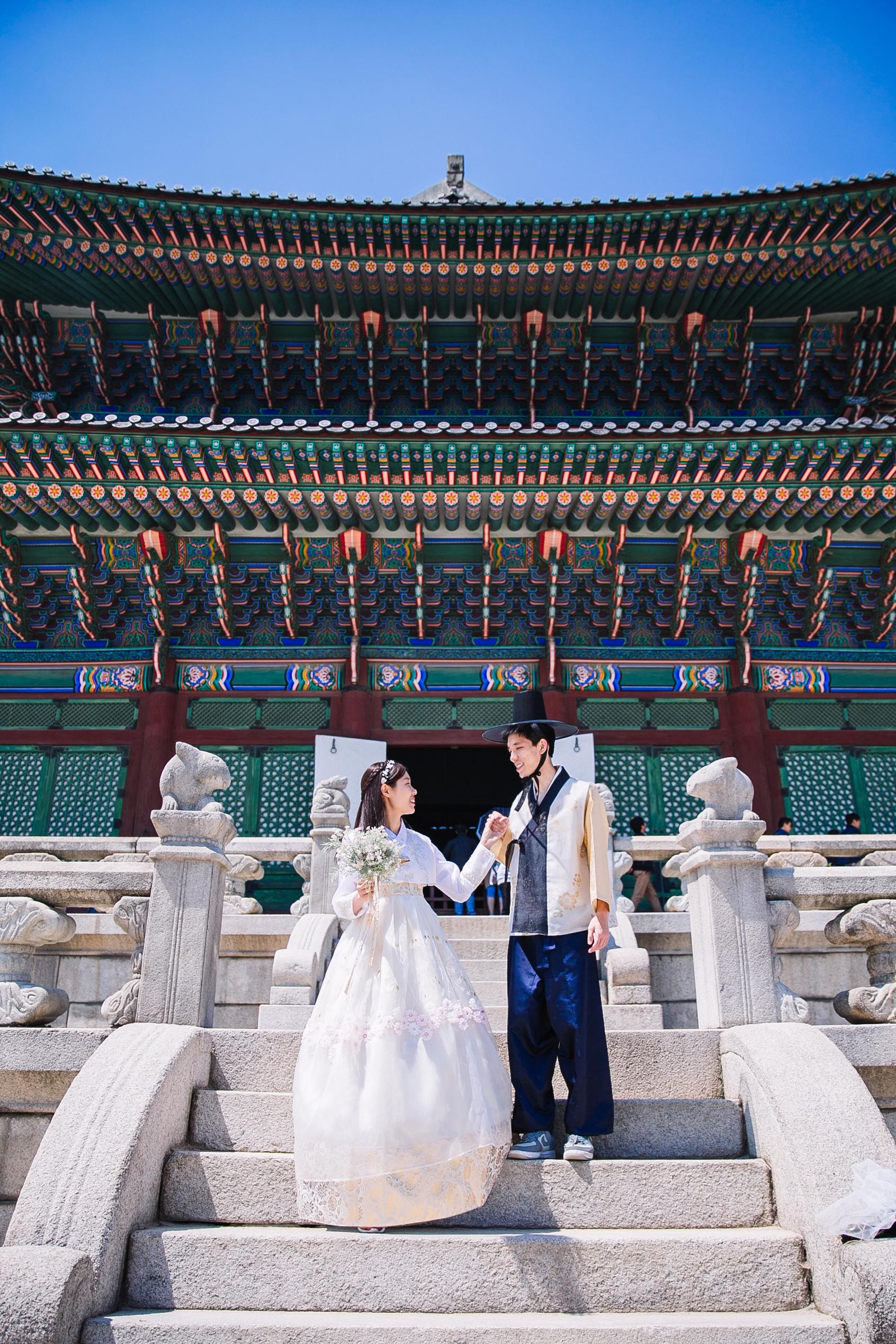 景福宮の階段で韓服を着たカップルが手をつないでいるシーン