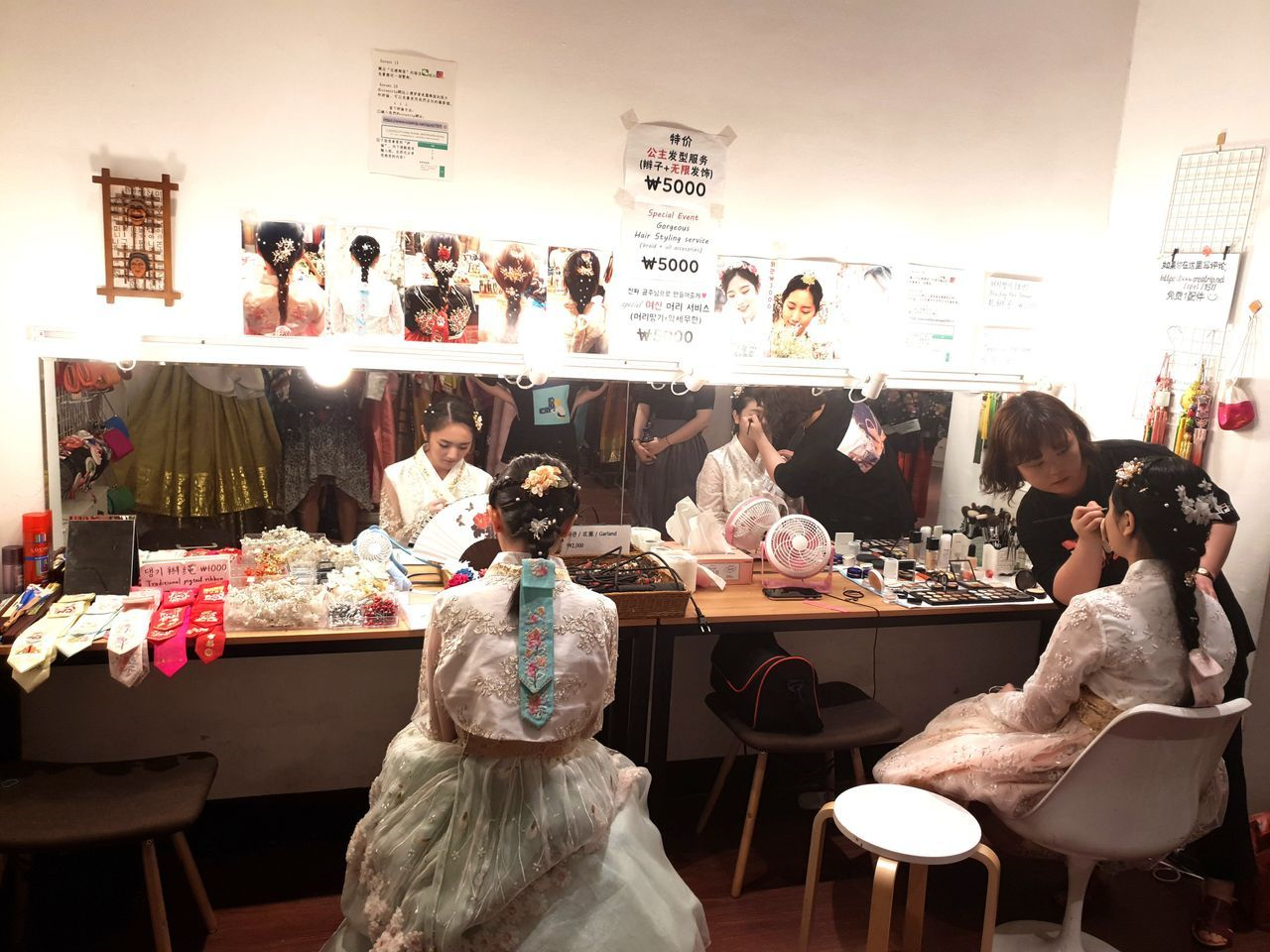 メイクルームで韓服に合ったヘアスタイルを整えている様子が見られる花様韓服の提供するメイクアップサービスの一場面。