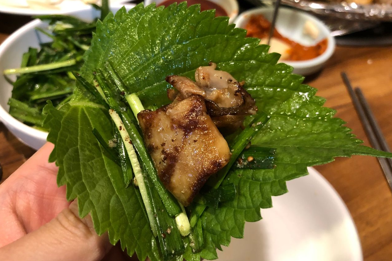 往十里夜間的韓式烤腸小巷，路邊小攤燈火通明，食客們正熱情地享用美味的韓國小吃。