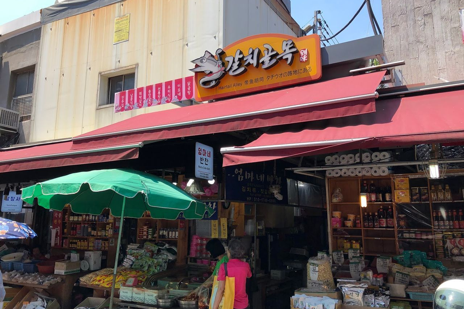 首爾南大門帶魚街的入口，帶著鮮亮顏色的招牌吸引食客前來尋找美味的帶魚料理。