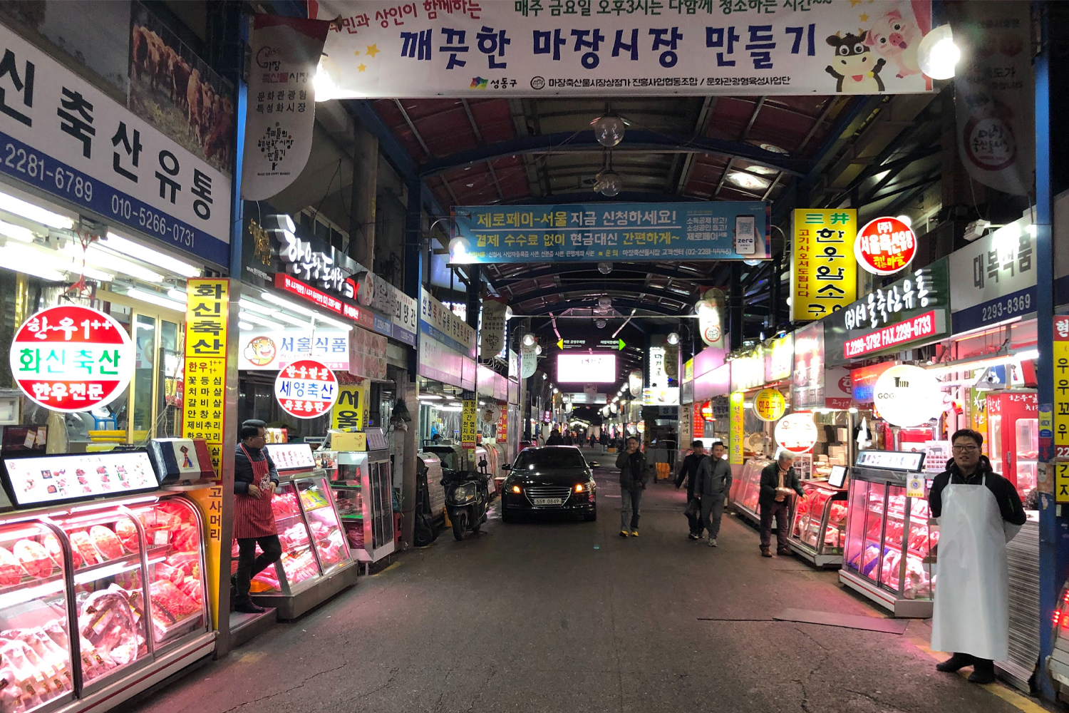 韓牛市場內，售賣著各式各樣的肉類，店內燈光明亮，顧客們在店員的引導下選購韓國最優質的牛肉。