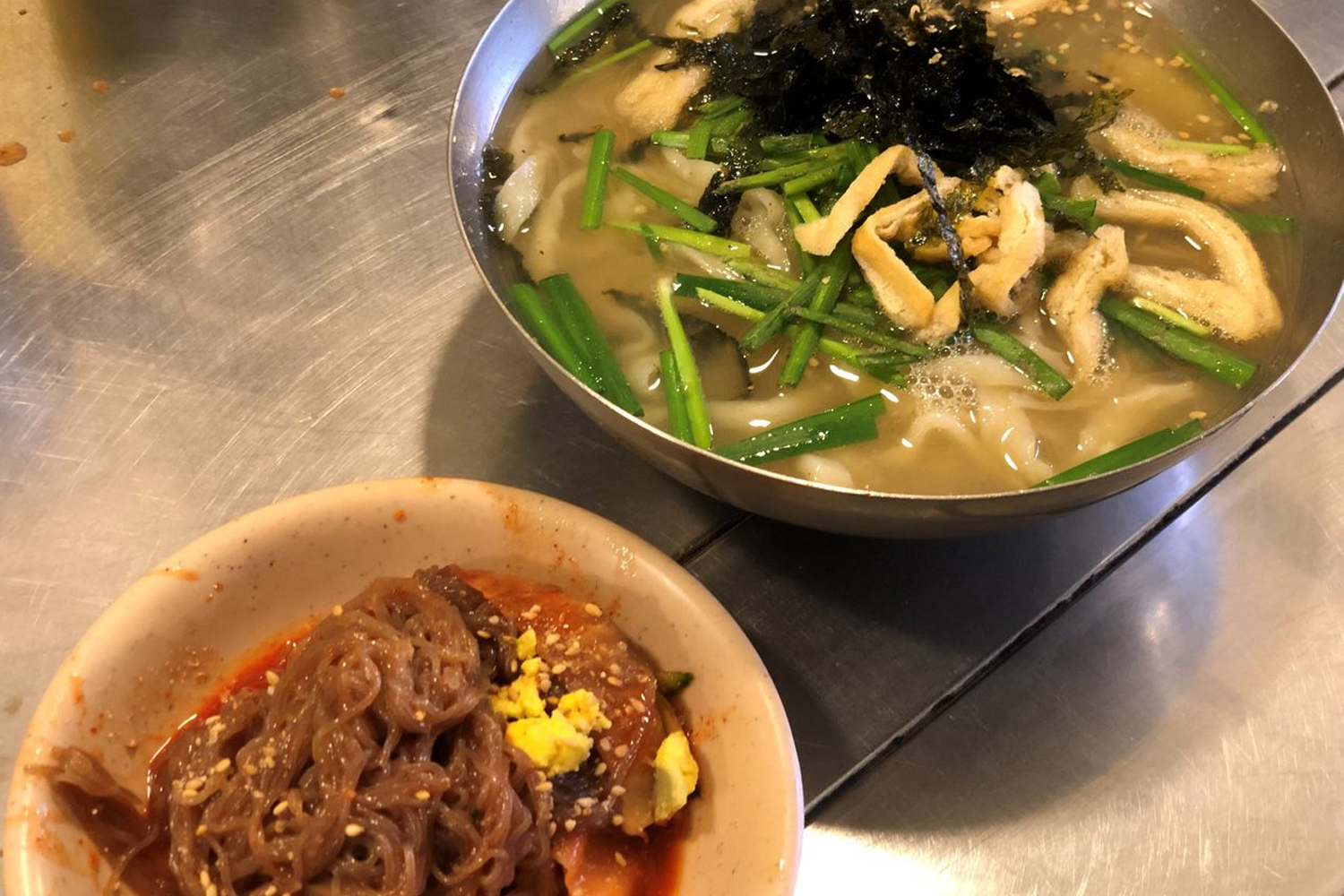 大碗熱騰騰的刀削麵，搭配爽口的涼菜與麵條，形成完美的韓式平民美食。