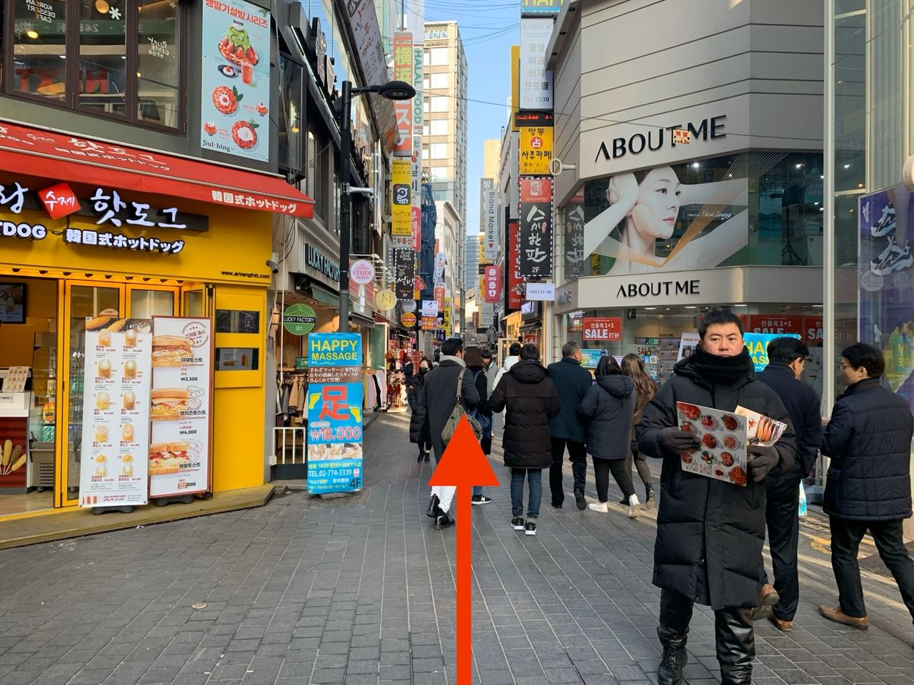 明洞の通りにあるABOUT MEとHotDogの店外観。賑わう街並みが印象的。