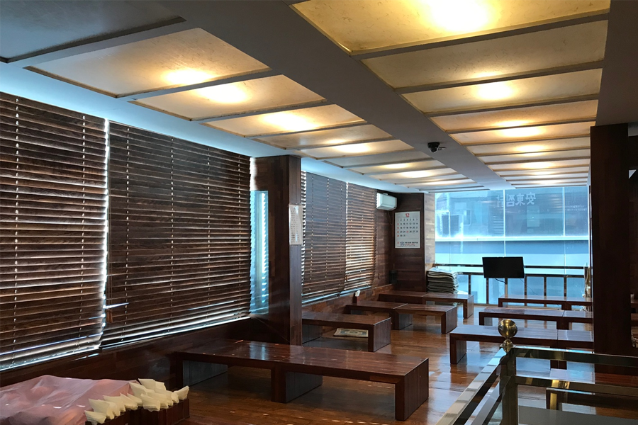 安东炖鸡餐厅内部拍摄，从窗外可以看到都市风景，装潢现代且简约。