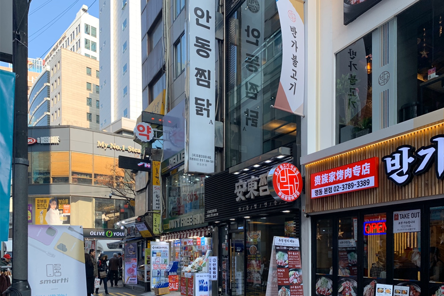 明洞街景图，显示韩国安東炖雞分店门口及附近的商业建筑。