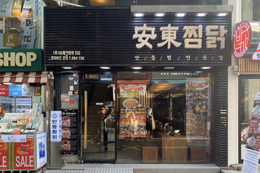 明洞安東炖雞入口，明亮的招牌显示餐厅名称，门面设计现代化。