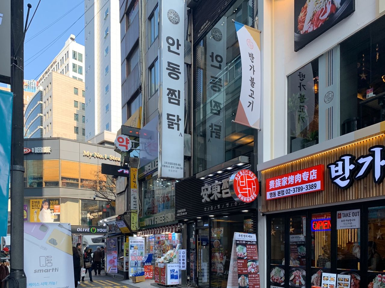 明洞で安東チムタクが見つかる通り。韓国料理の看板が並ぶにぎやかなエリア。