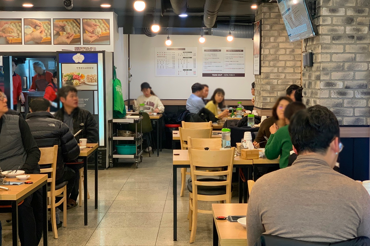 聖經餃子料理專門店的室內環境，展示了坐得滿滿的顧客和明亮的餐廳裝潢。