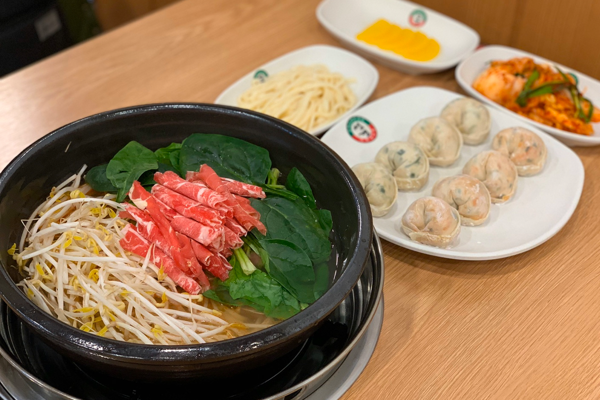 聖經餃子小菜自助區，展示了泡菜和泡菜蘿蔔，顧客可隨意添加。