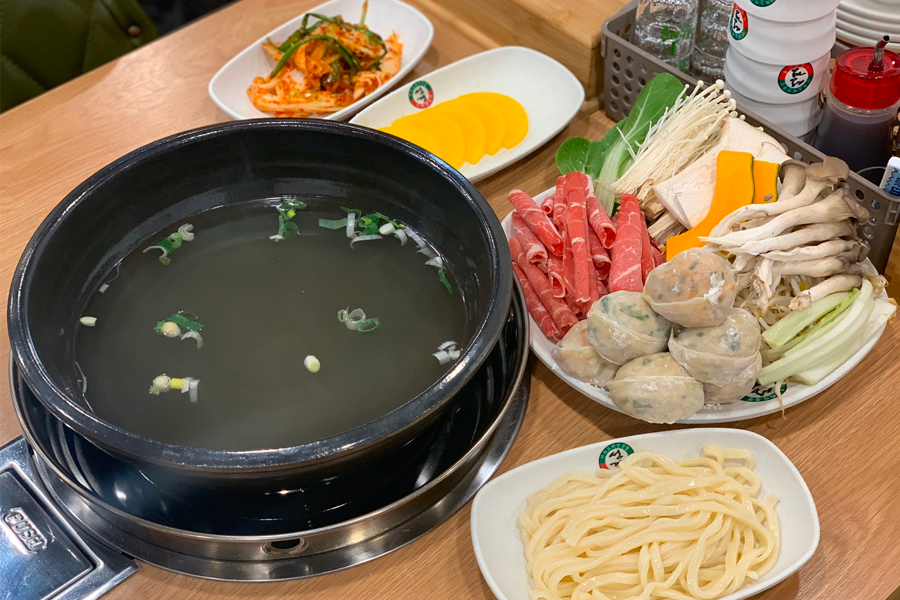 韓國首爾聖經餃子店的紅湯餃子鍋，韓國泡菜和餃子搭配湯頭辛辣爽口。