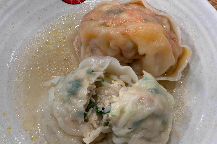 韓國首爾聖經餃子店的白湯餃子鍋，泡菜餃子正煮著，湯頭清淡不辣。