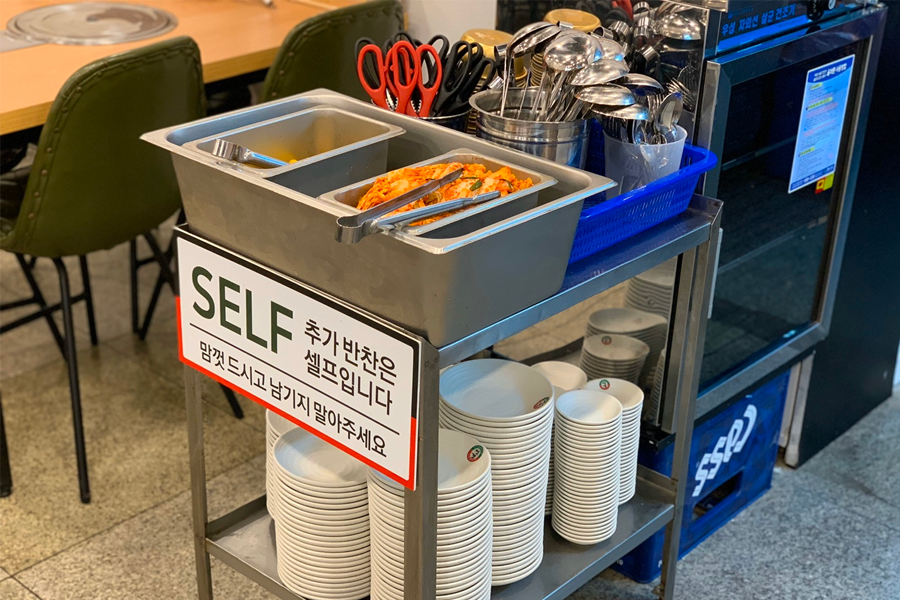 韓國首爾聖經餃子店內，設有自助的泡菜和醃蘿蔔可以取用。