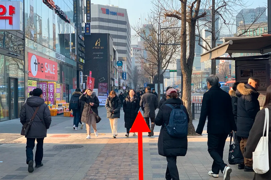 走在韓國首爾鐘路3街街道上的行人，地鐵站出口通往聖經餃子店。