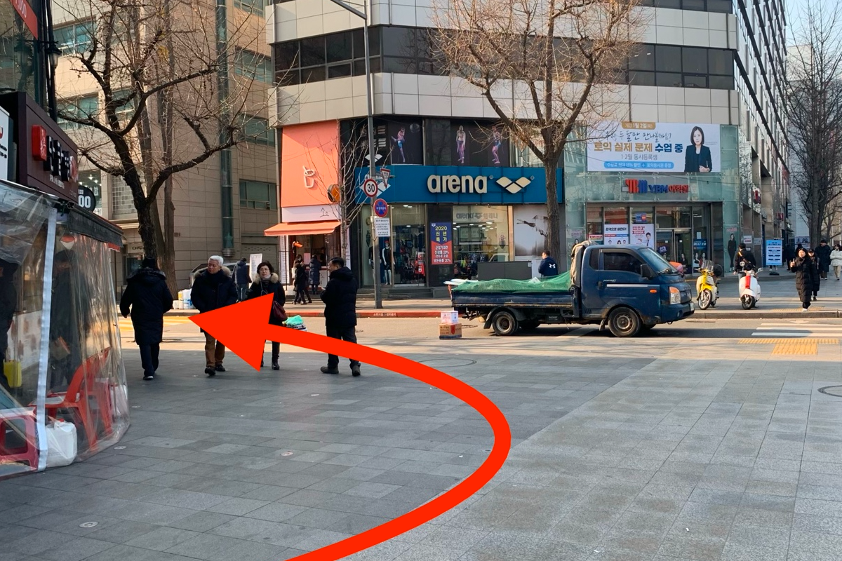 十字路口的行人與車輛交會的繁忙幹道，行人正在過街至左側。