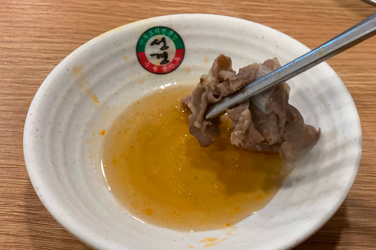 熱騰騰的白湯火鍋，內有新鮮食材蘸著香濃湯底翻滾，餃子與牛肉條完美結合。