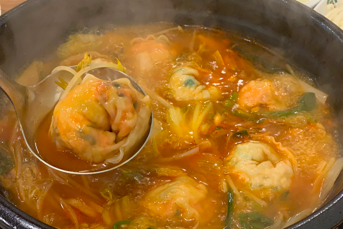 用手工餃子放入熱騰騰火鍋中的一瞬間，餃子湯汁在火鍋中翻滾。