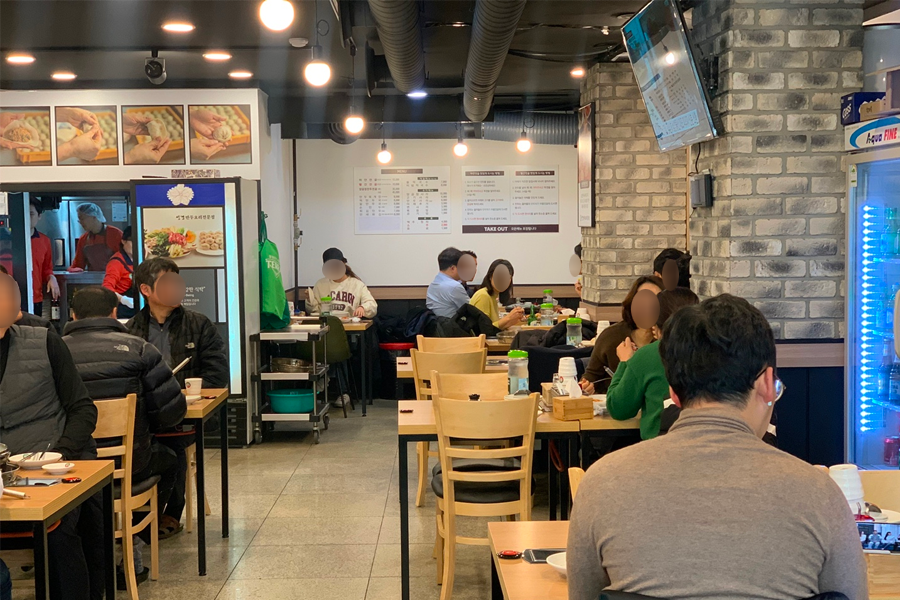 拜訪韓國首爾的聖經餃子店內部用餐環境，店內顧客坐滿桌子，享用美味的餃子餐點。
