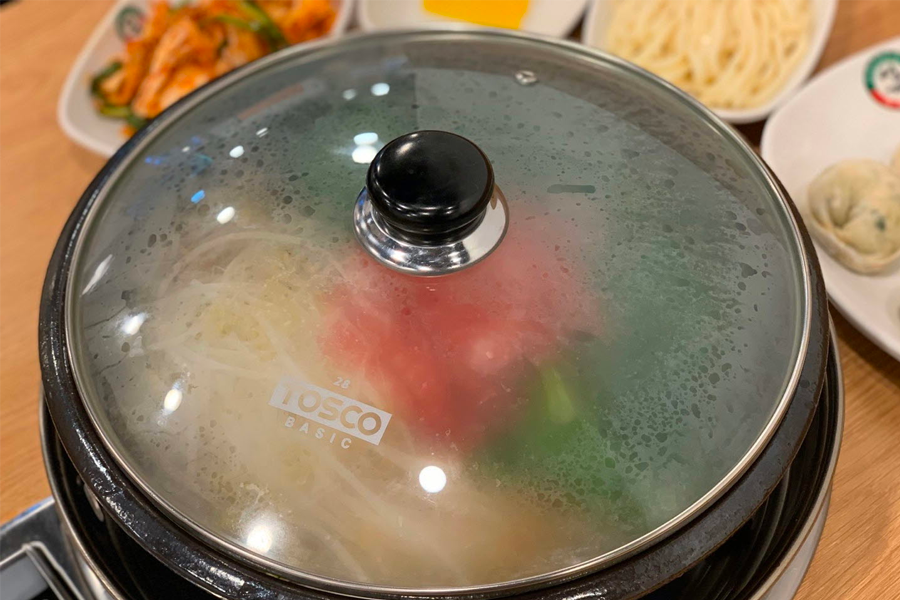 在韓國首爾聖經餃子店享用紅湯餃子鍋，等待餃子煮熟。