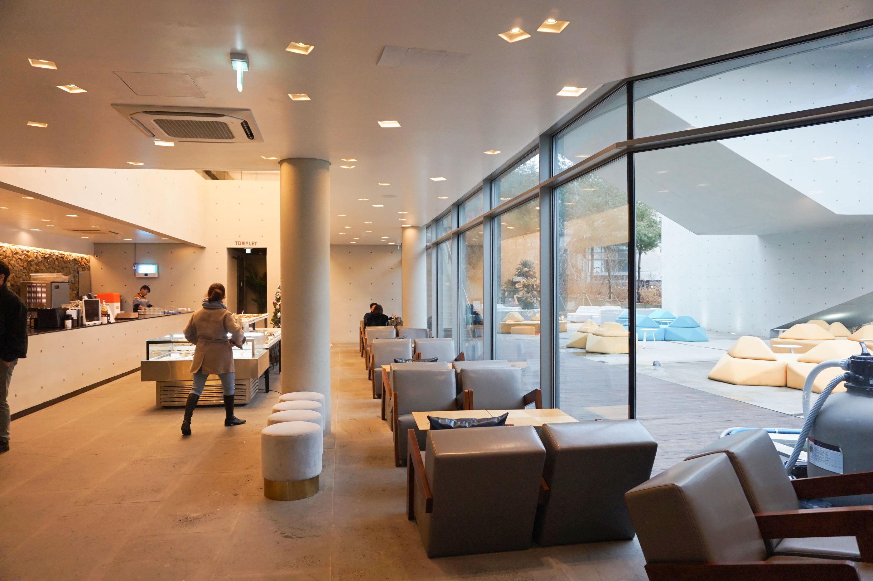 Lounge-Bereich im GARDENUS Café in Paju mit bequemen Sitzmöglichkeiten und schlichtem Design.