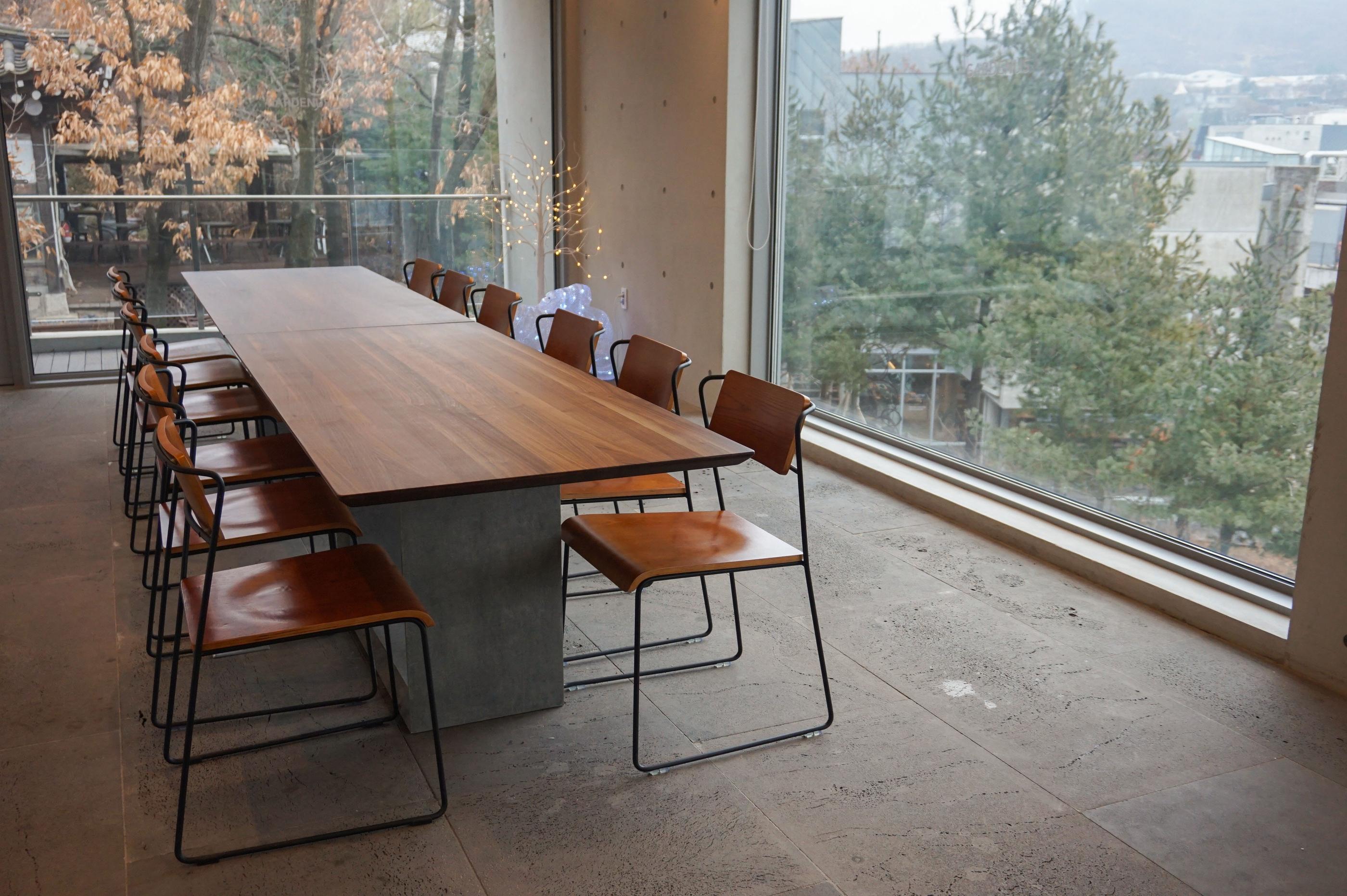 Großer Tisch im dritten Stock des GARDENUS Cafés in Paju, ideal für Gruppen.