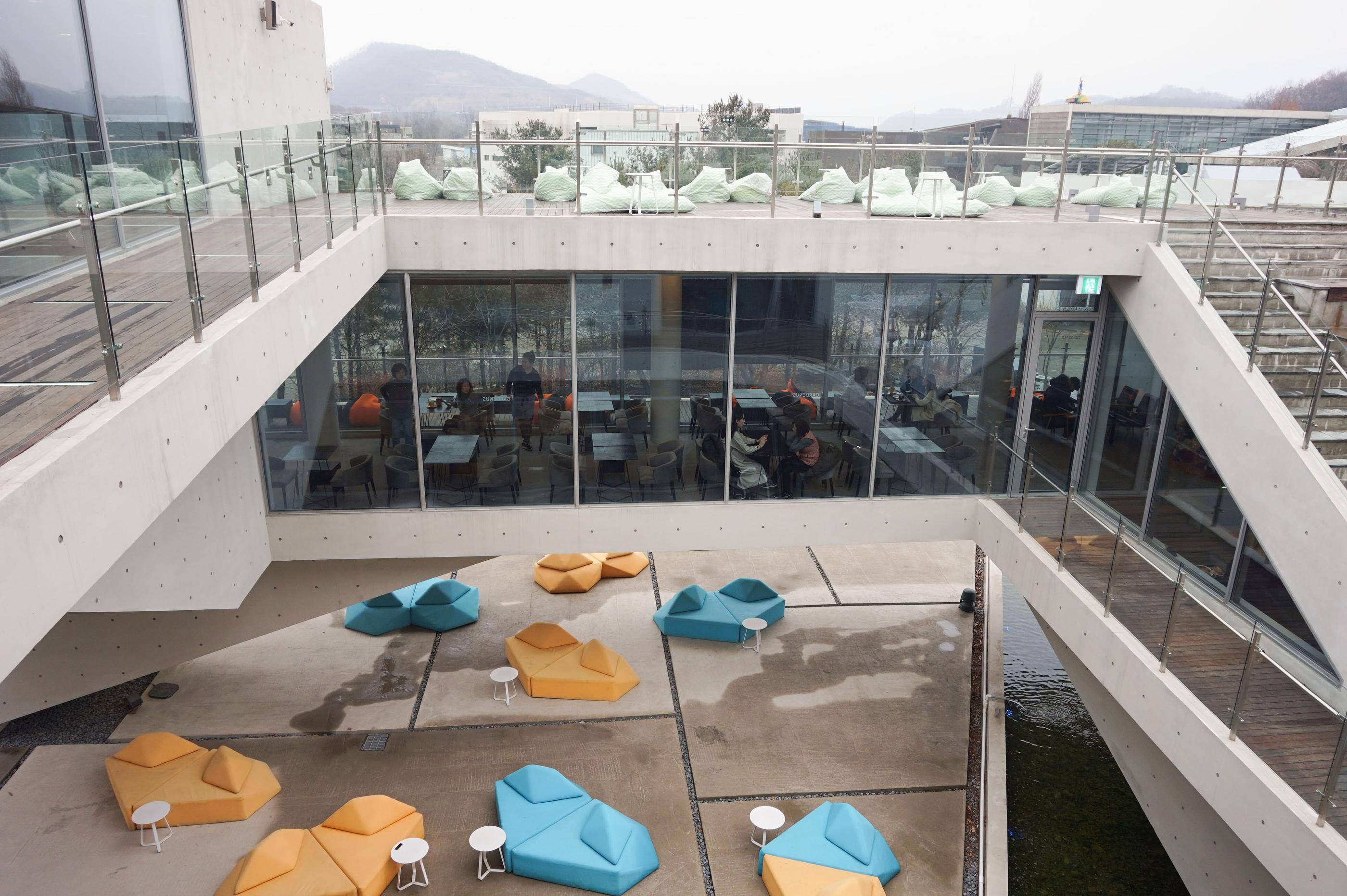 Große Außenterrasse im GARDENUS Café in Paju mit vielseitigen Farb- und Sitzdesigns.