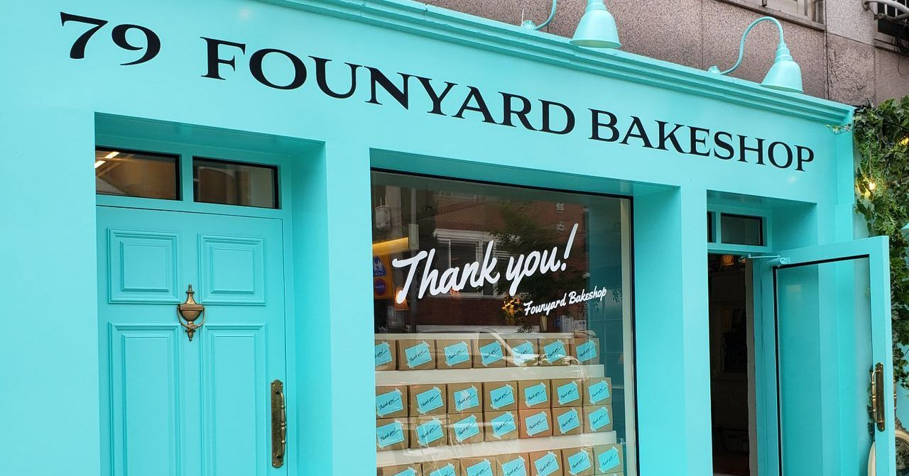 79 Founyard Bakeshop的外觀，顯示了一家時尚的藍色外牆糕點店，店內似乎堆滿了精美的糕點禮品盒和裝飾讓人感受到一種愉悦的氛圍。