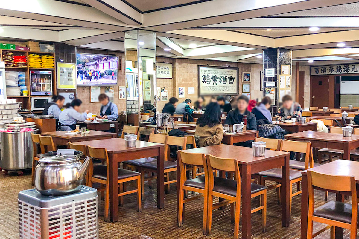 百濟蔘雞湯餐廳內部，顧客正享用韓國傳統料理，典雅的裝潢反映餐廳悠久的歷史。