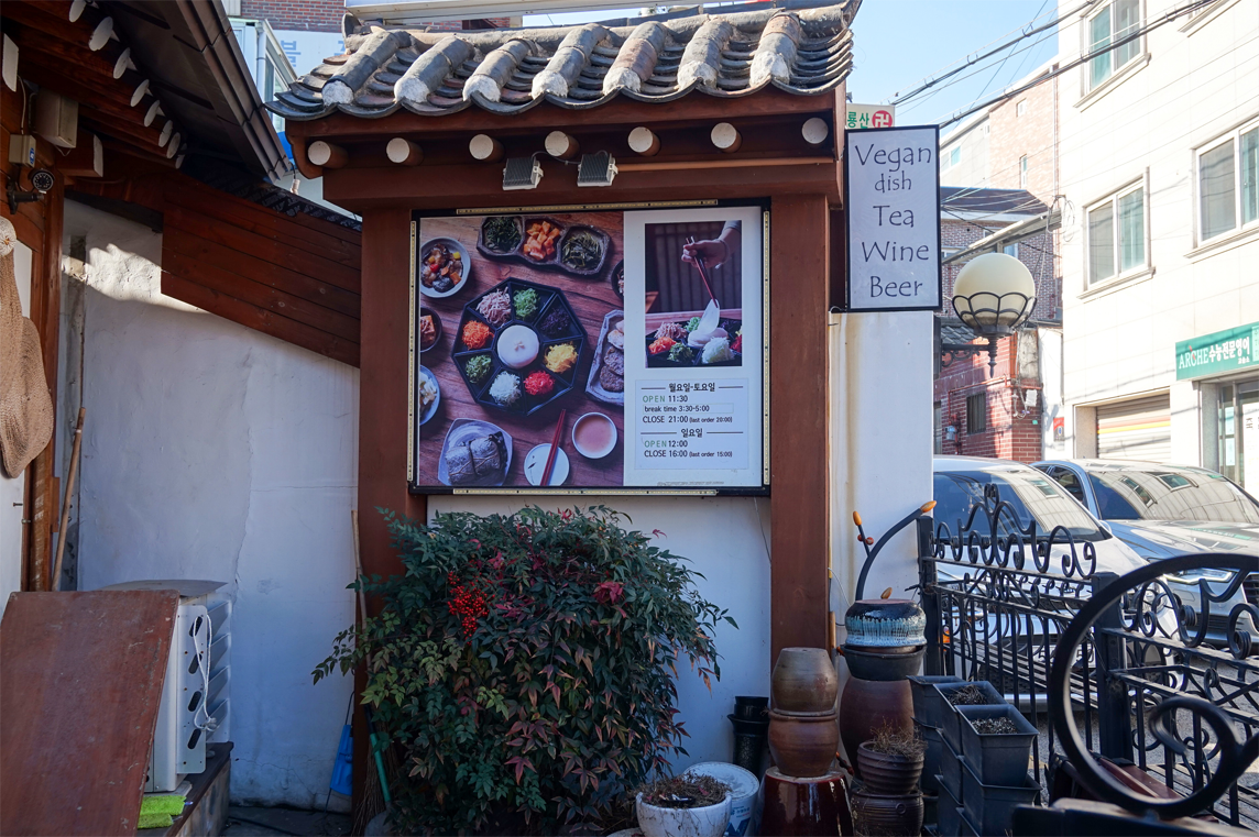 Maji餐廳的外景，有關於菜品和營業時間的告示牌。