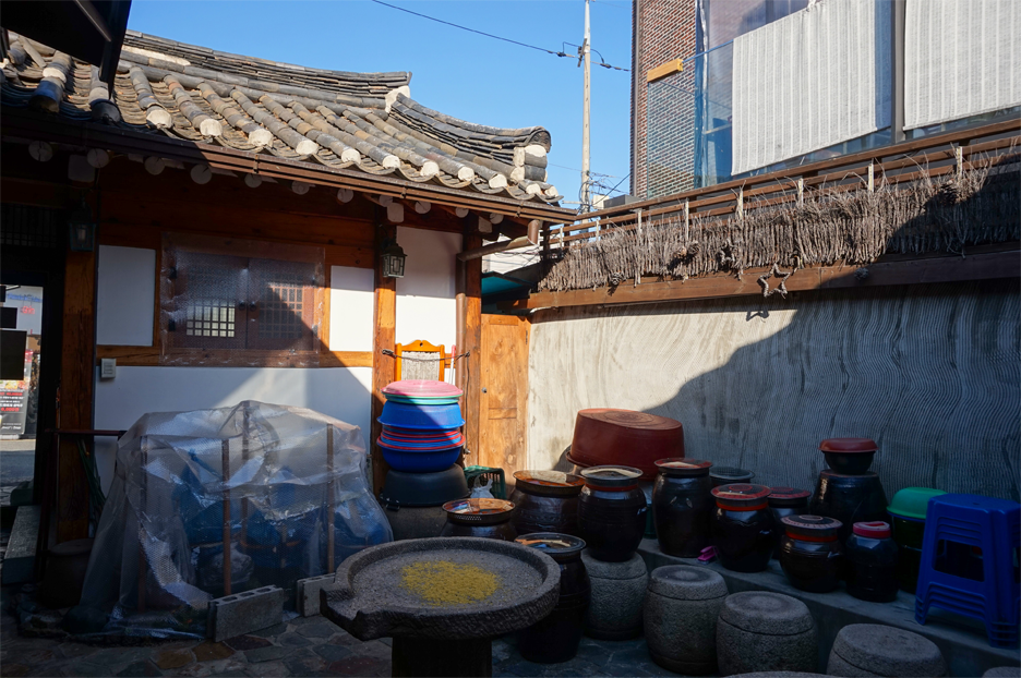 咖啡色的陶器和用於發酵的容器，位於Maji素食餐廳的庭院內。