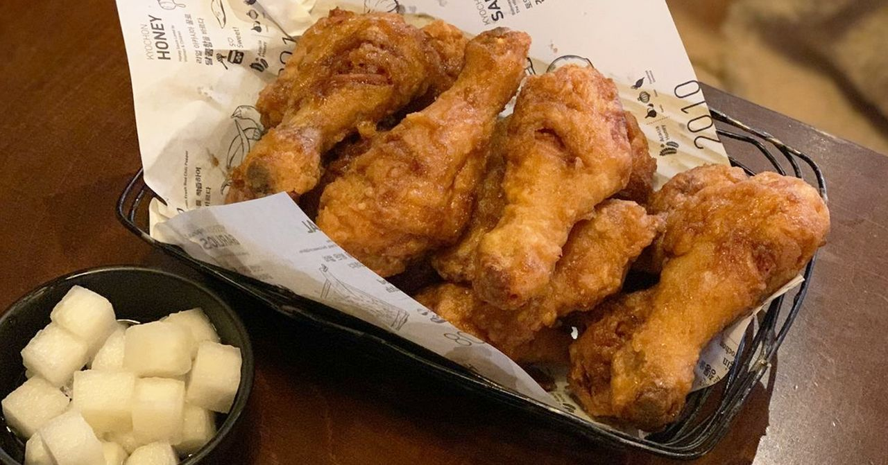 弘大橋村炸雞金黃色澄脆外皮誘人,配有一小碗白蘿蔔,是韓國人氣食物之一