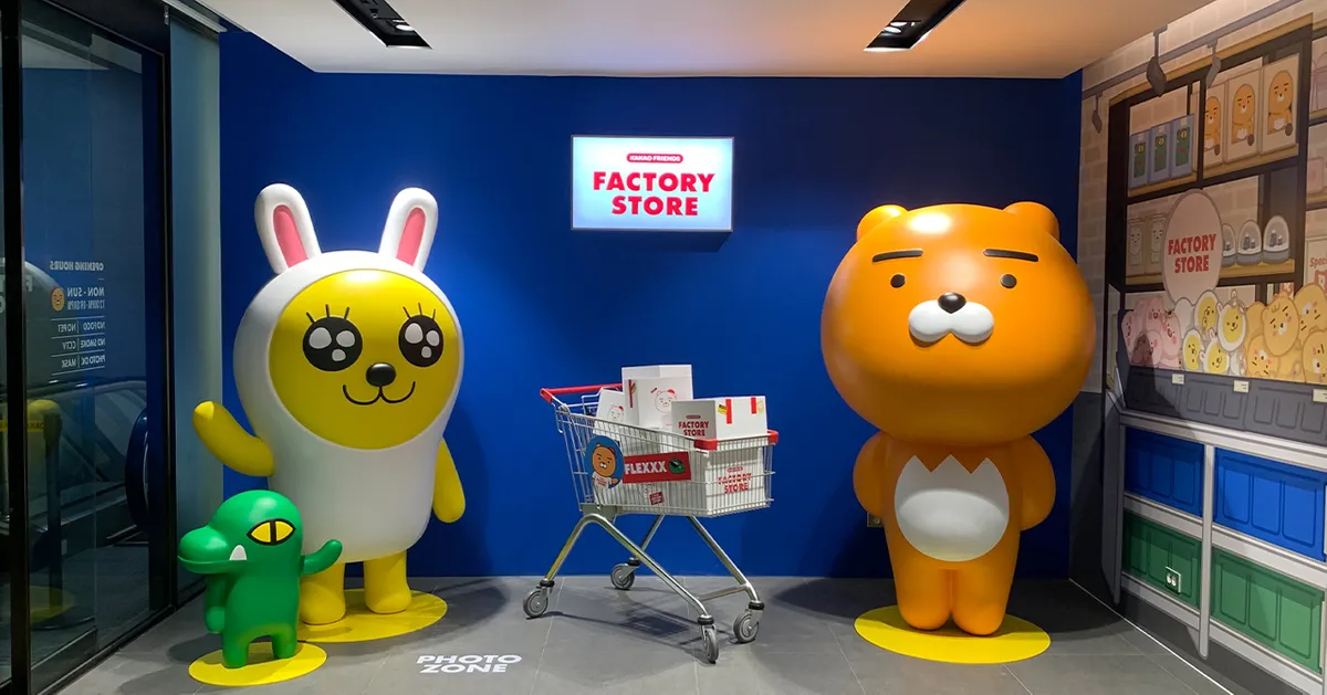Kakao Outlet店内一角，有卡通人物装饰和购物推车，营造出活泼的购物气氛。