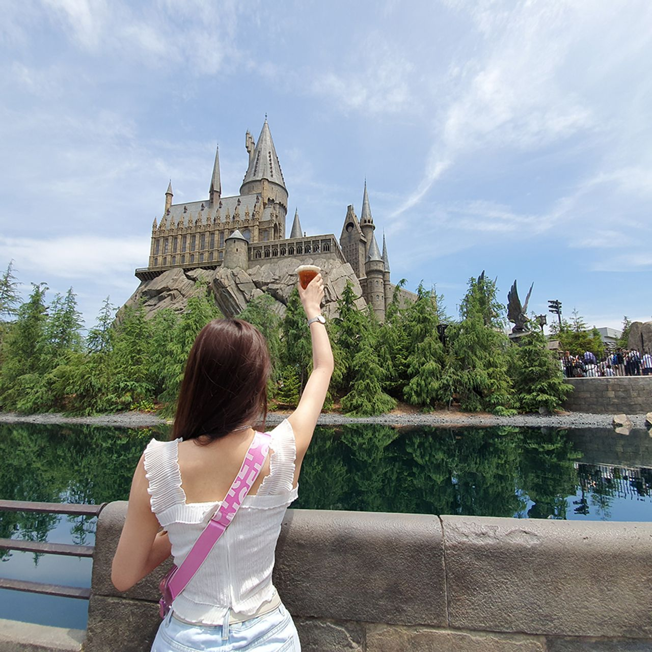 手持奶油啤酒，看向哈利波特城堡，陽光下的夏日遊樂園氣息撲面而來。