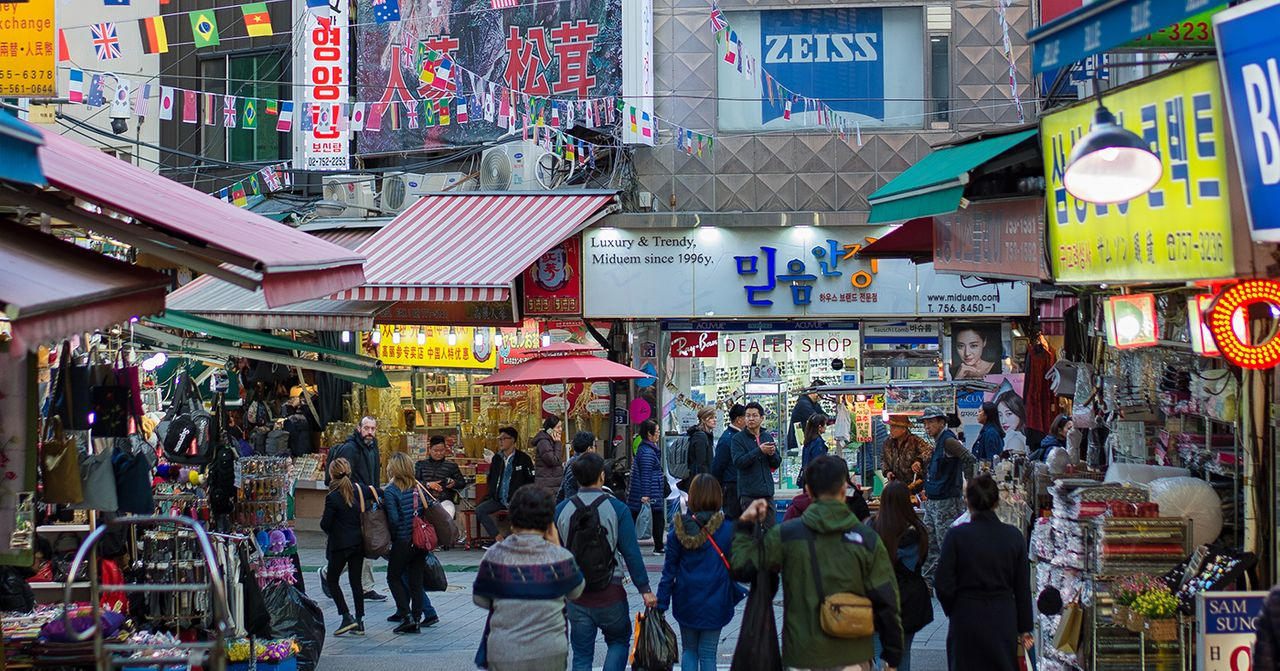南大門市場的繁忙街道，旗幟飄揚、各國遊客留下的市集景象