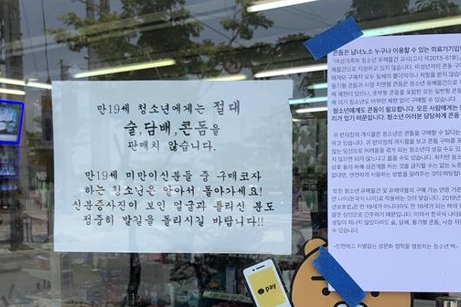 韩国便利店窗户上的告示，禁止向19岁以下未成年人出售酒类、烟草和安全套的警示标语。